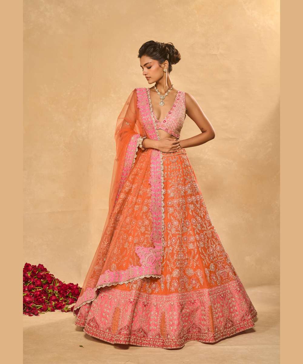 MAHIRA LEHENGA - Orange organza lehenga exquisitely embellished with a pink appliqué hem encrusted in intricate zari, resham, pearl, and glass bead paired with a delicately scalloped V-neck blouse - Leher by Chamee and Palak