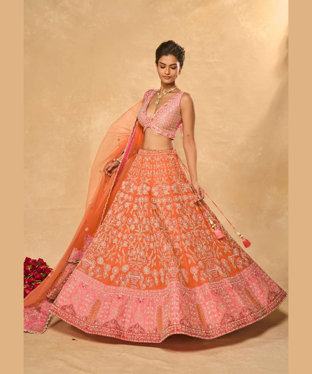 MAHIRA LEHENGA - Orange organza lehenga exquisitely embellished with a pink appliqué hem encrusted in intricate zari, resham, pearl, and glass bead paired with a delicately scalloped V-neck blouse - Leher by Chamee and Palak