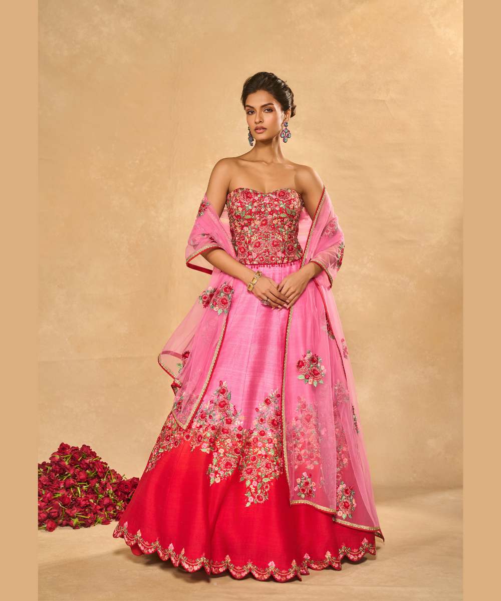 TANYA OMBRE LEHENGA - Pink tor Red ombré lehenga, adorned with delicately embroidered floral motifs in resham and zari paired with a red raw silk corset blouse - Leher by Chamee and Palak
