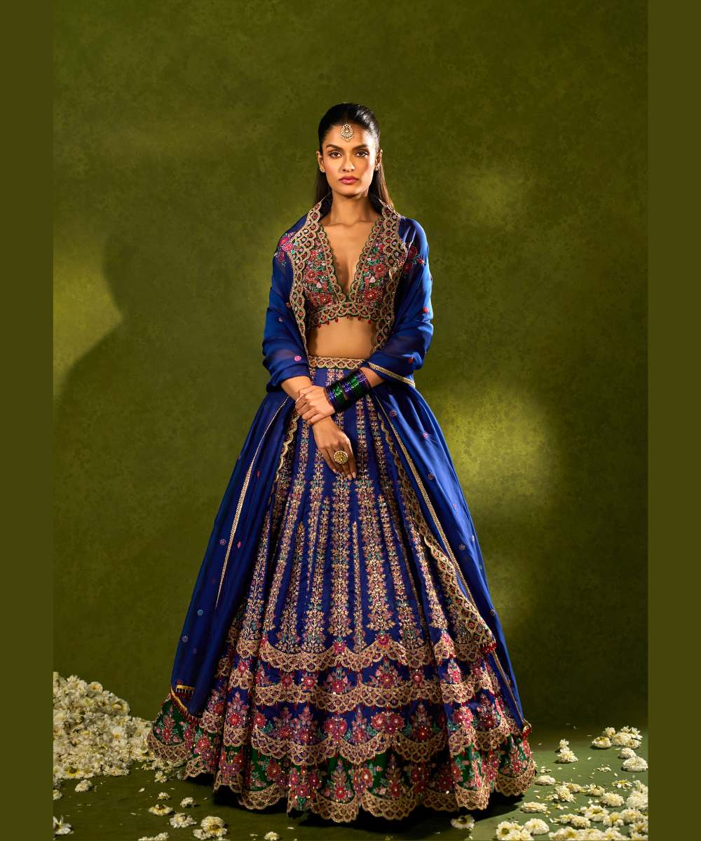 OORJA LEHENGA - Blue and green soft silk lehenga exquisitely embellished with vibrant resham, zari, pearls, and sequence work, in a graceful scallop pattern paired with a green, intricately embroidered plunging-neck blouse - Leher by Chamee and Palak