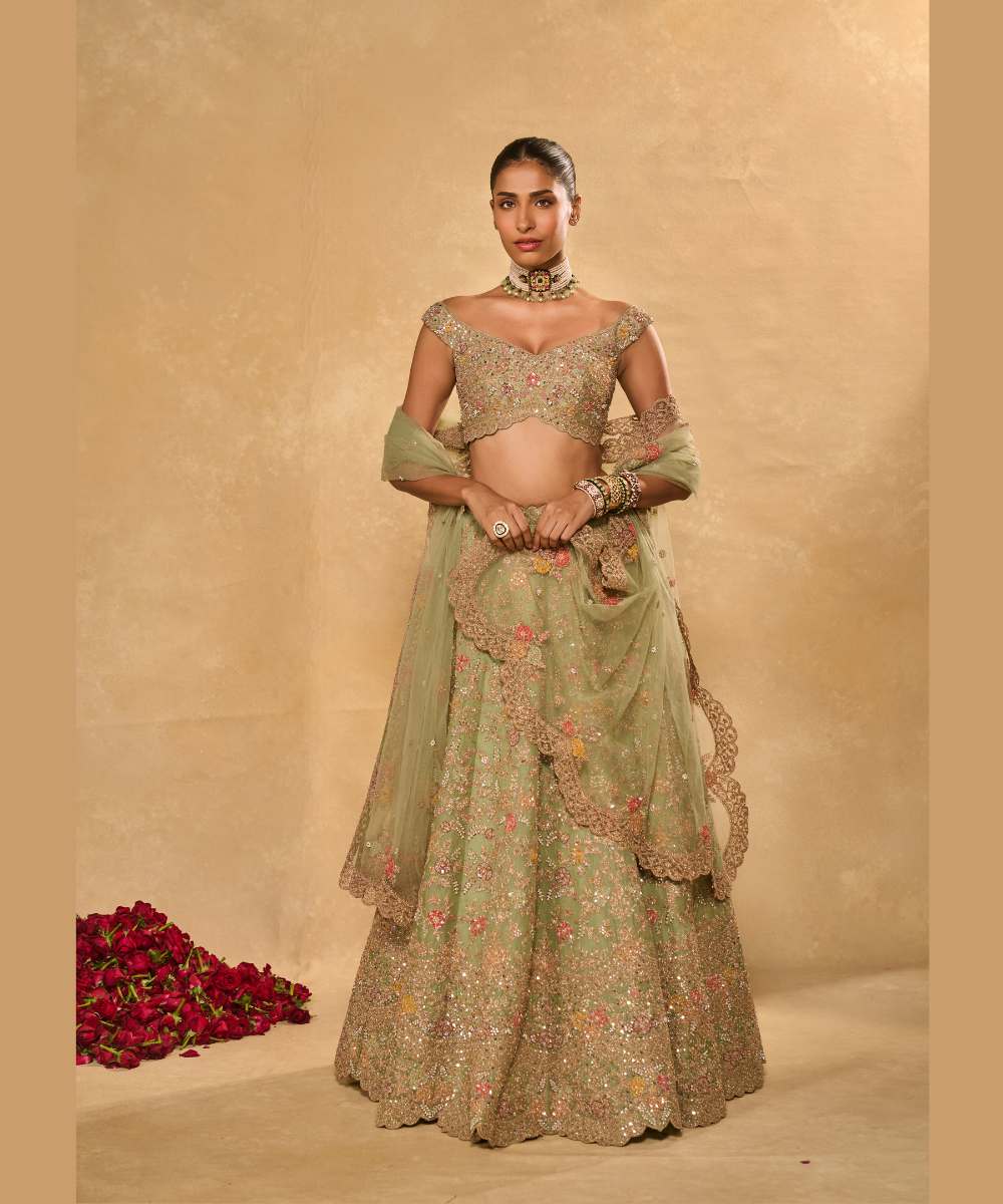 REVATI LEHENGA - Light Sage Green organza lehenga adorned with intricate zari thread, sequence, and pearl embroidery paired with a stunning floral-embellished off-shoulder blouse - Leher by Chamee and Palak