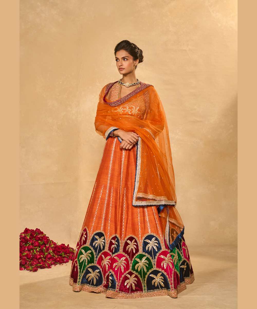 MAPLE LEHENGA - Raw silk lehenga with finely embroidered velvet palm appliqué in blue, maroon, green, and pink, highlighted with glass beads paired with a delicately embellished high-neck décolleté plunge blouse - Leher by Chamee and Palak