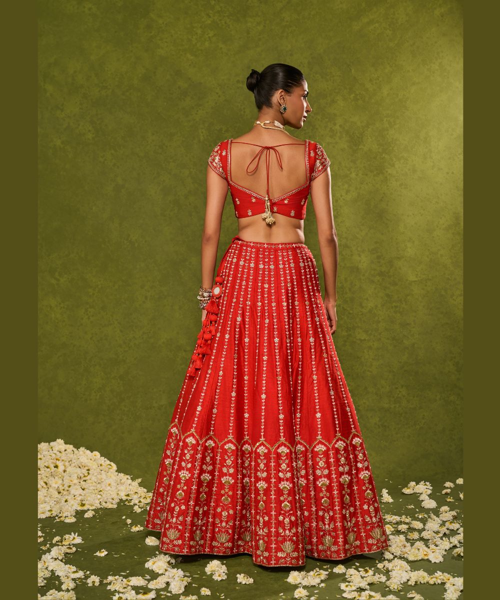 ANANDI LEHENGA - Red raw silk lehenga meticulously crafted with intricate resham, zardozi, pearl and glass beadwork paired with a zardozi-embellished floral work cap sleeve blouse -  Leher by Chamee and Palak