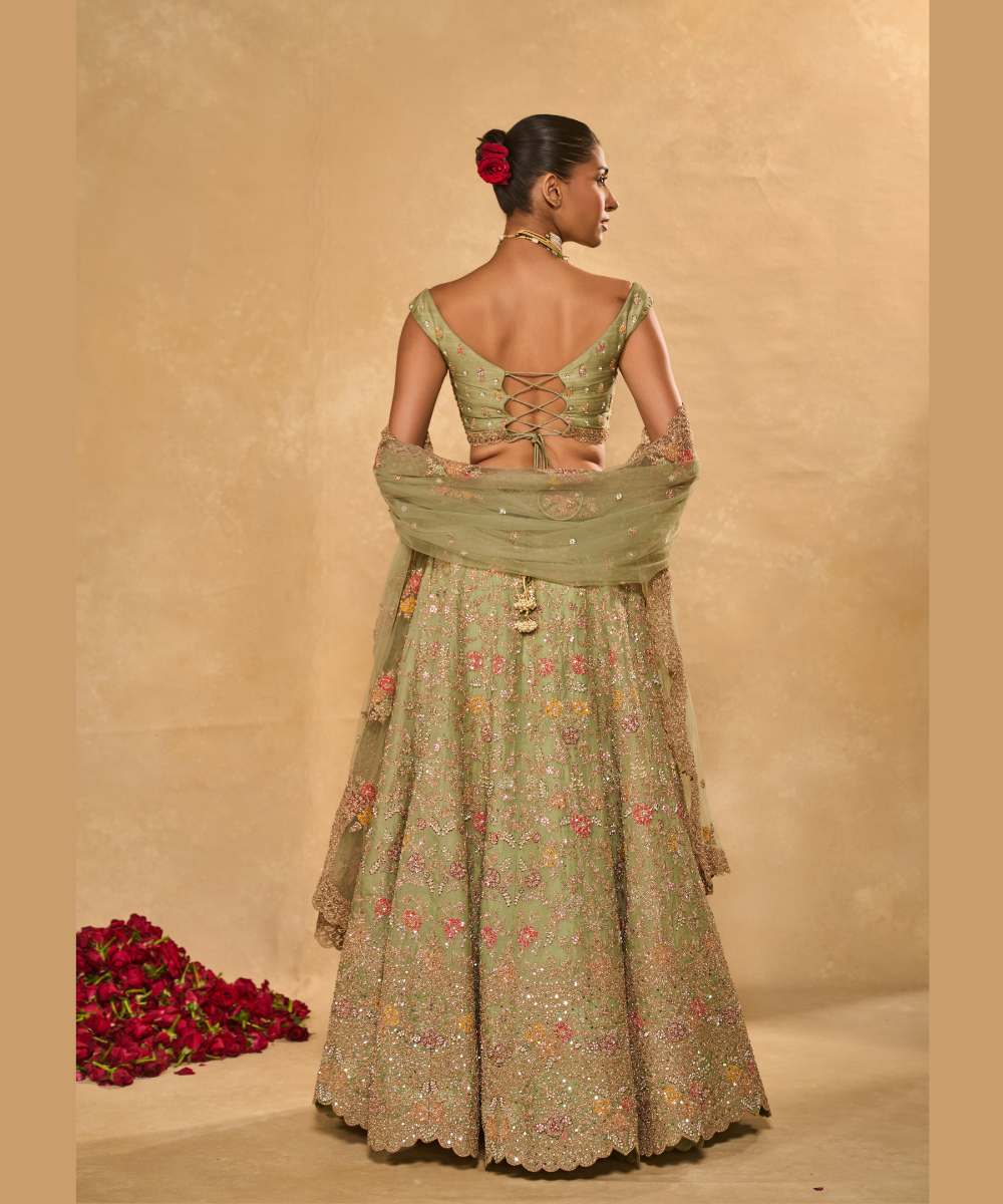 REVATI LEHENGA - Light Sage Green organza lehenga adorned with intricate zari thread, sequence, and pearl embroidery paired with a stunning floral-embellished off-shoulder blouse - Leher by Chamee and Palak