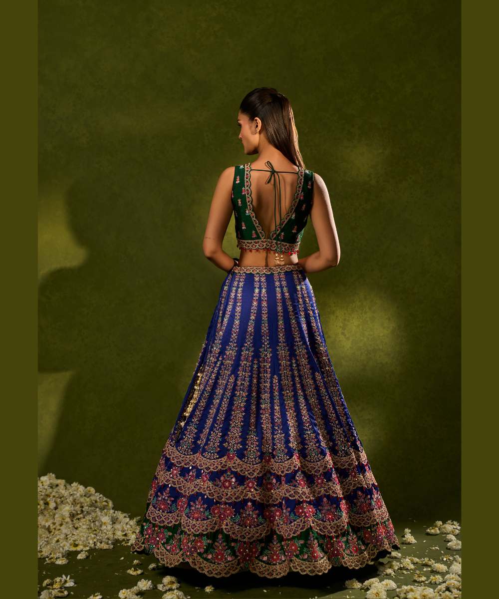 OORJA LEHENGA - Blue and green soft silk lehenga exquisitely embellished with vibrant resham, zari, pearls, and sequence work, in a graceful scallop pattern paired with a green, intricately embroidered plunging-neck blouse - Leher by Chamee and Palak
