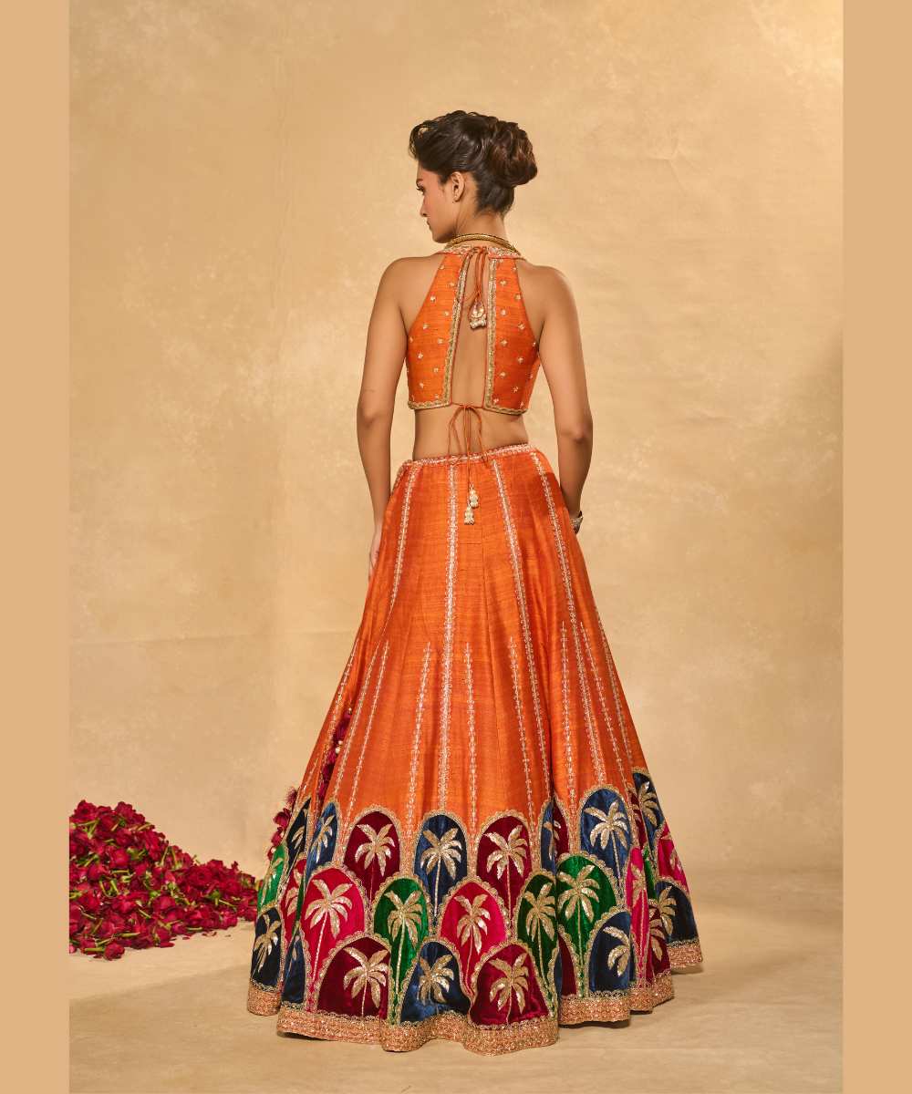 MAPLE LEHENGA - Raw silk lehenga with finely embroidered velvet palm appliqué in blue, maroon, green, and pink, highlighted with glass beads paired with a delicately embellished high-neck décolleté plunge blouse - Leher by Chamee and Palak