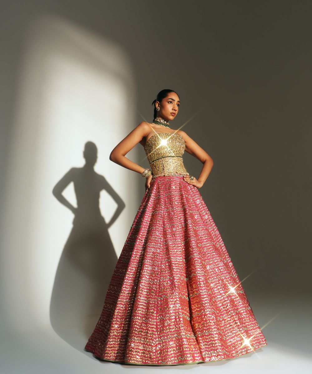 GARIMA - HAND EMBROIDERED RANI PINK LEHENGA WITH GOLDEN CORSET -  Mehfil by Mahima Mahajan