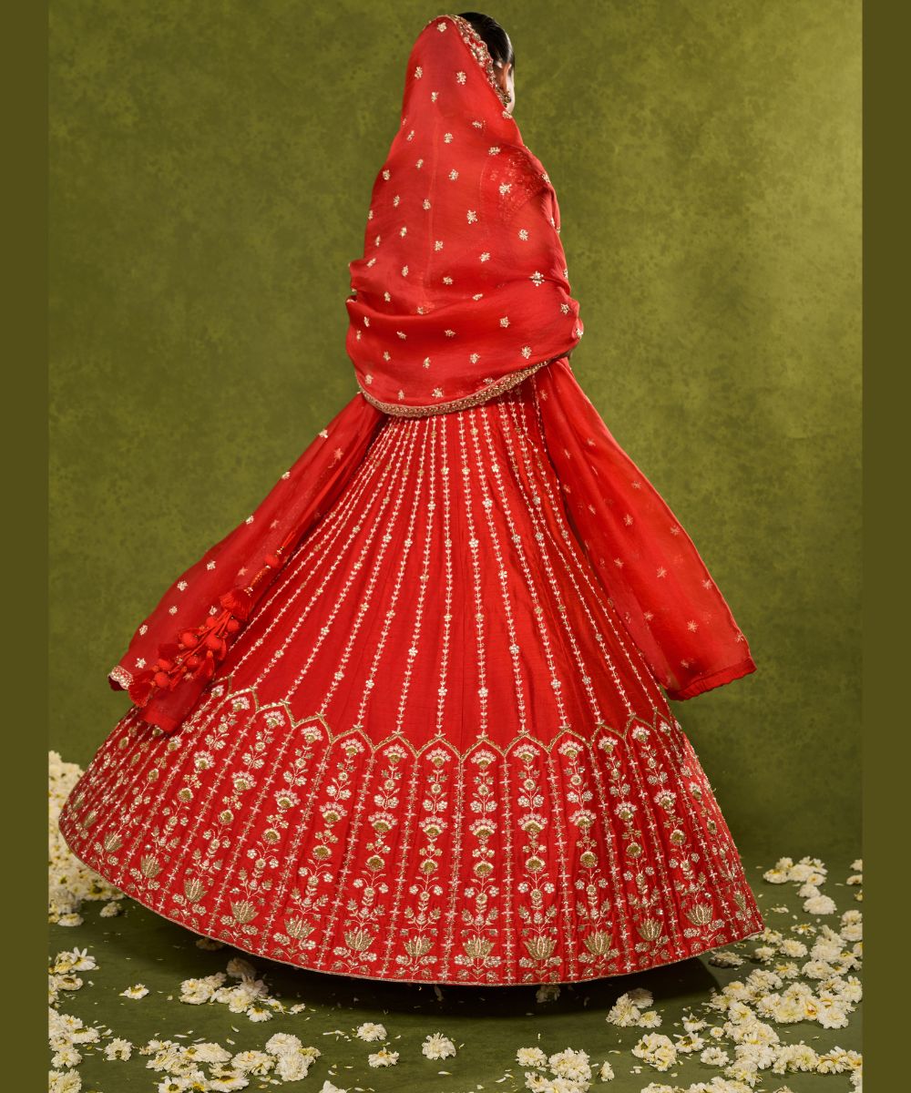 ANANDI LEHENGA - Red raw silk lehenga meticulously crafted with intricate resham, zardozi, pearl and glass beadwork paired with a zardozi-embellished floral work cap sleeve blouse -  Leher by Chamee and Palak