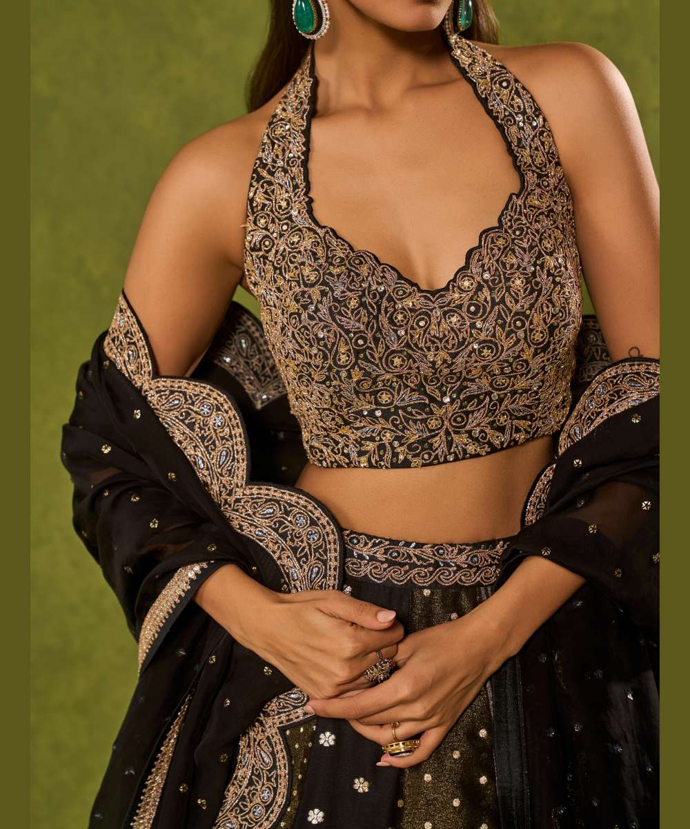 NANDANA LEHENGA - Black tissue woven jamewar lehenga delicately embroidered with a zari hem paired with a richly embroidered halter-neck blouse - Leher by Chamee and Palak