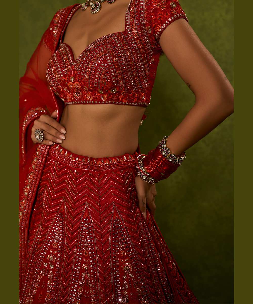 INDIRA LEHENGA - Red raw silk floral embroidered lehenga with thread, sequence, zardozi and glassbeads detailing paired with a sweetheart neck cap sleeve heavily embroidered blouse - Leher by Chamee and Palak