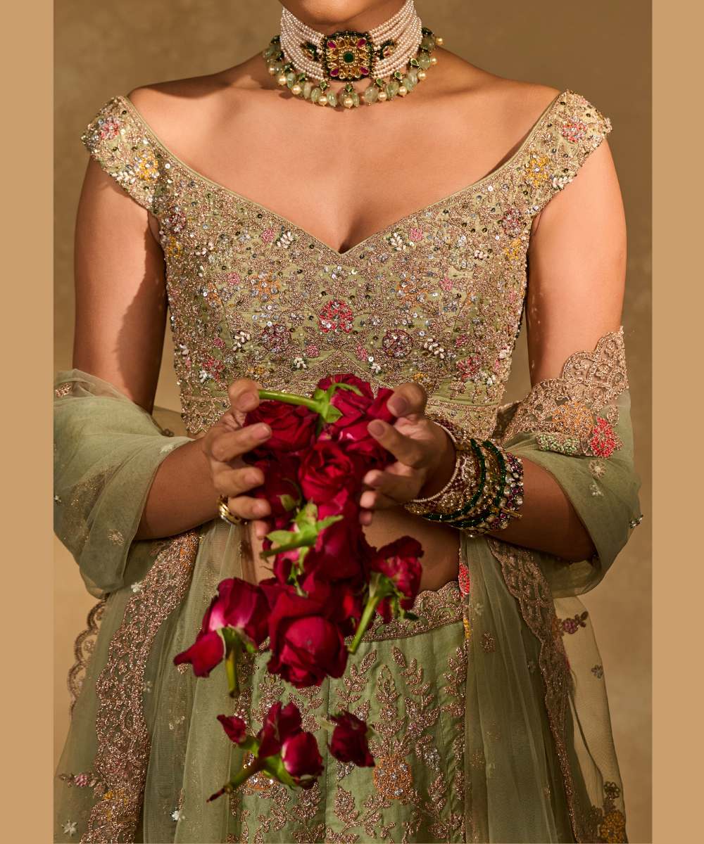 REVATI LEHENGA - Light Sage Green organza lehenga adorned with intricate zari thread, sequence, and pearl embroidery paired with a stunning floral-embellished off-shoulder blouse - Leher by Chamee and Palak