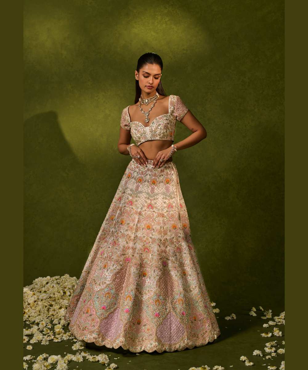 KIARA LEHENGA - Ivory organza lehenga adorned with intricate zari thread, sequence, and pearl embroidery paired with a stunning floral embellished blouse -  Leher by Chamee and Palak