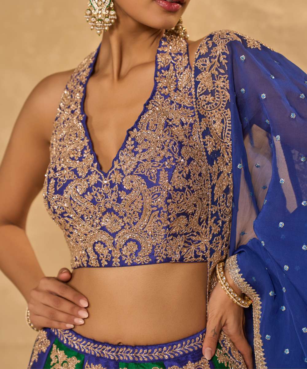 SAIRA LEHENGA - Silk lehenga embellished with luminous zari embroidery, paired with a blue halter neck blouse -  Leher by Chamee and Palak