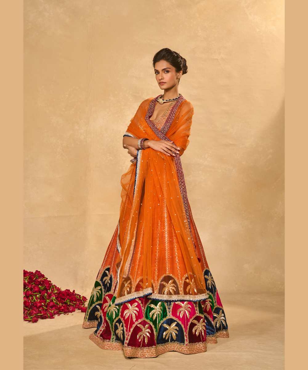 MAPLE LEHENGA - Raw silk lehenga with finely embroidered velvet palm appliqué in blue, maroon, green, and pink, highlighted with glass beads paired with a delicately embellished high-neck décolleté plunge blouse - Leher by Chamee and Palak