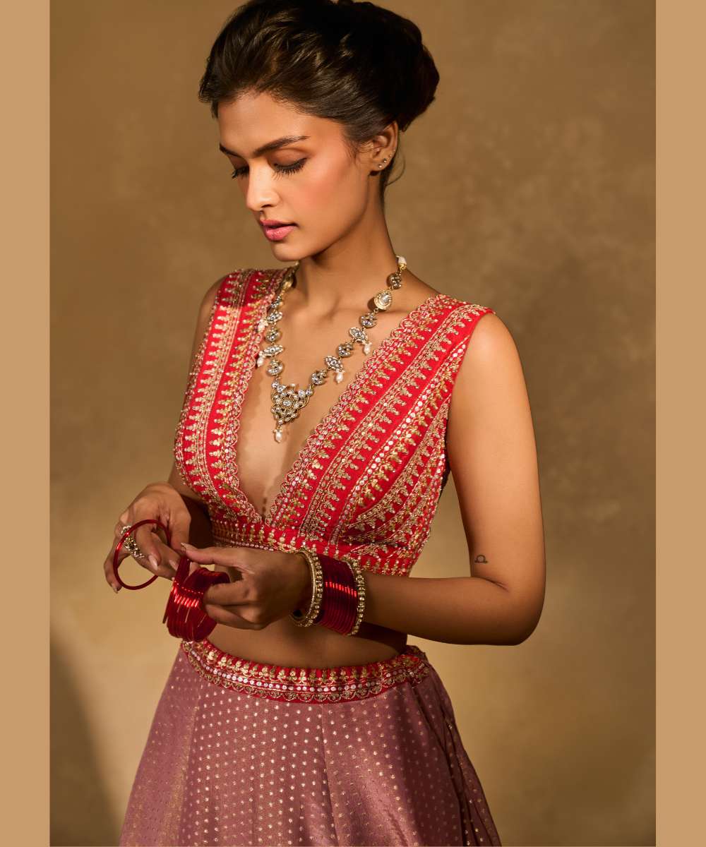 MINA DAMAN LEHENGA - Tissue jamewar lehenga accented with pita and zari embroidery along a contrast red hem paired with a delicately embroidered red plunging neck blouse - Leher by Chamee and Palak