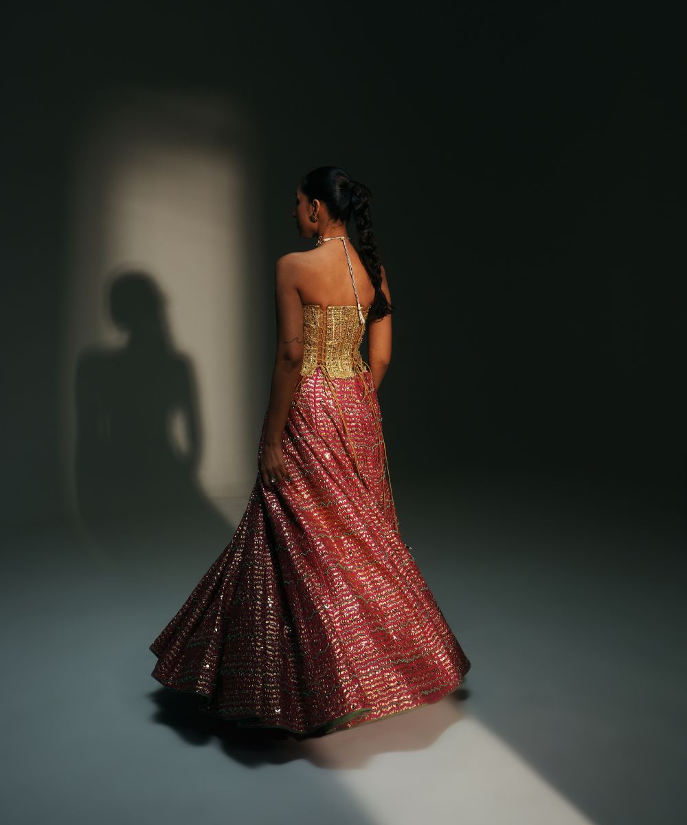 GARIMA - HAND EMBROIDERED RANI PINK LEHENGA WITH GOLDEN CORSET -  Mehfil by Mahima Mahajan