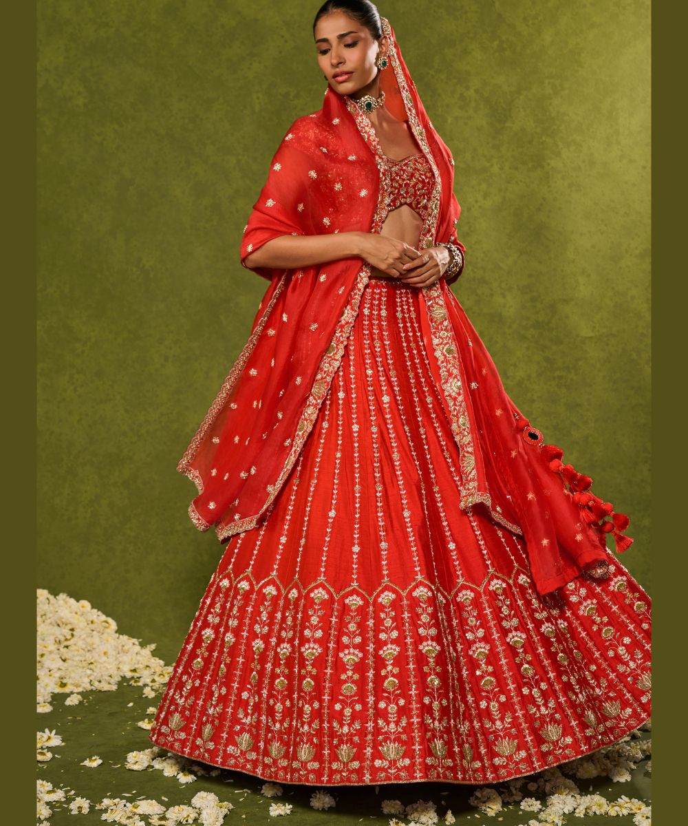 ANANDI LEHENGA - Red raw silk lehenga meticulously crafted with intricate resham, zardozi, pearl and glass beadwork paired with a zardozi-embellished floral work cap sleeve blouse -  Leher by Chamee and Palak