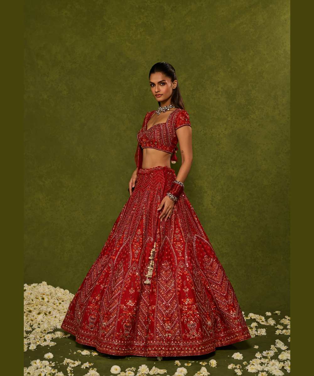 INDIRA LEHENGA - Red raw silk floral embroidered lehenga with thread, sequence, zardozi and glassbeads detailing paired with a sweetheart neck cap sleeve heavily embroidered blouse - Leher by Chamee and Palak
