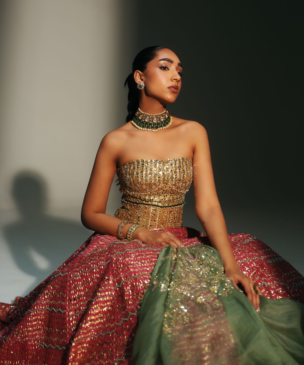 GARIMA - HAND EMBROIDERED RANI PINK LEHENGA WITH GOLDEN CORSET -  Mehfil by Mahima Mahajan
