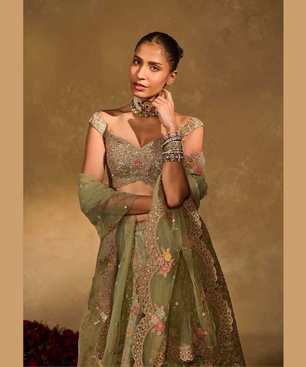 REVATI LEHENGA - Light Sage Green organza lehenga adorned with intricate zari thread, sequence, and pearl embroidery paired with a stunning floral-embellished off-shoulder blouse - Leher by Chamee and Palak
