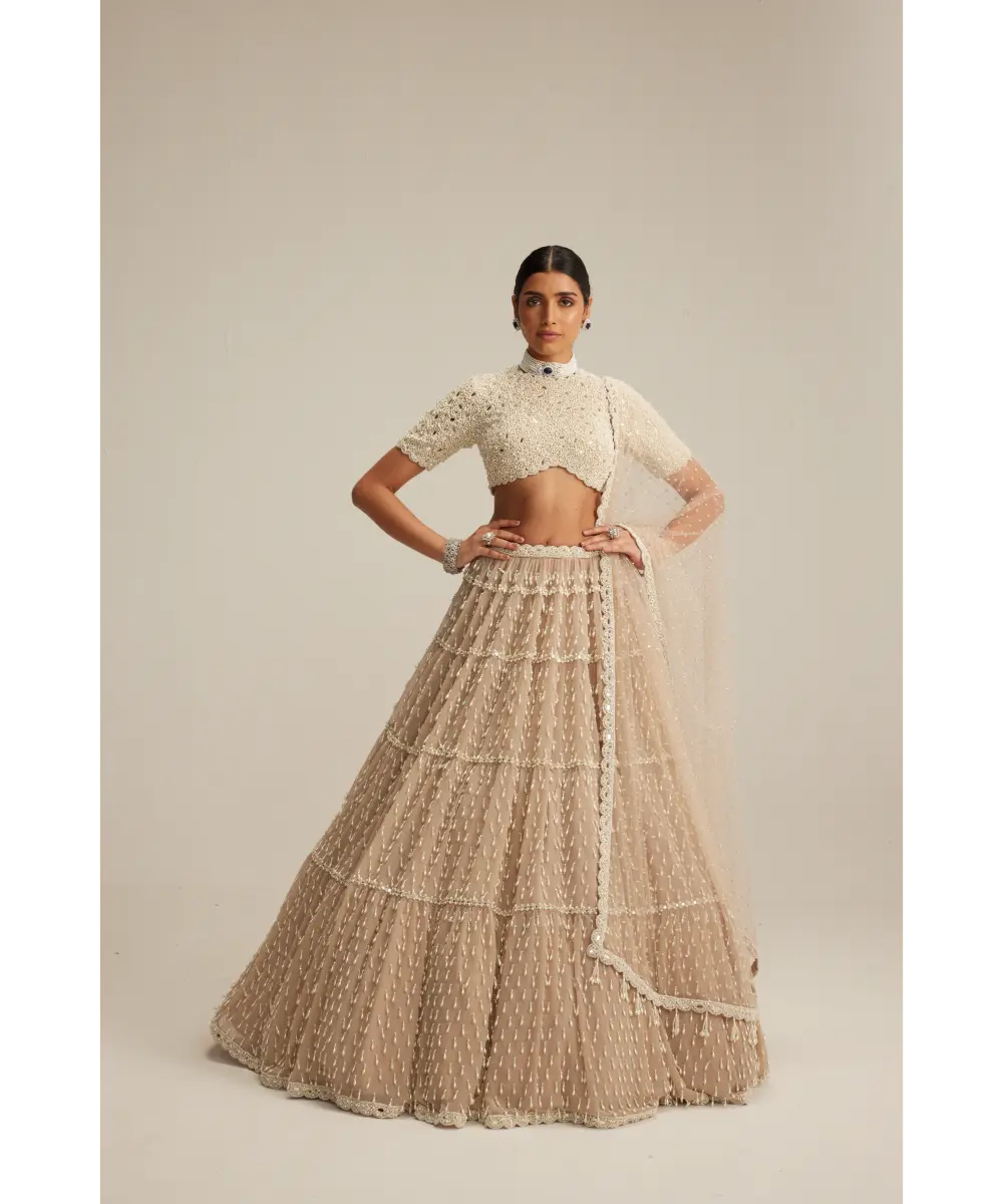 VVANI VATS- Light Beige Pearl Drop Multi Tier Lehenga With High Neck Blouse Set.
