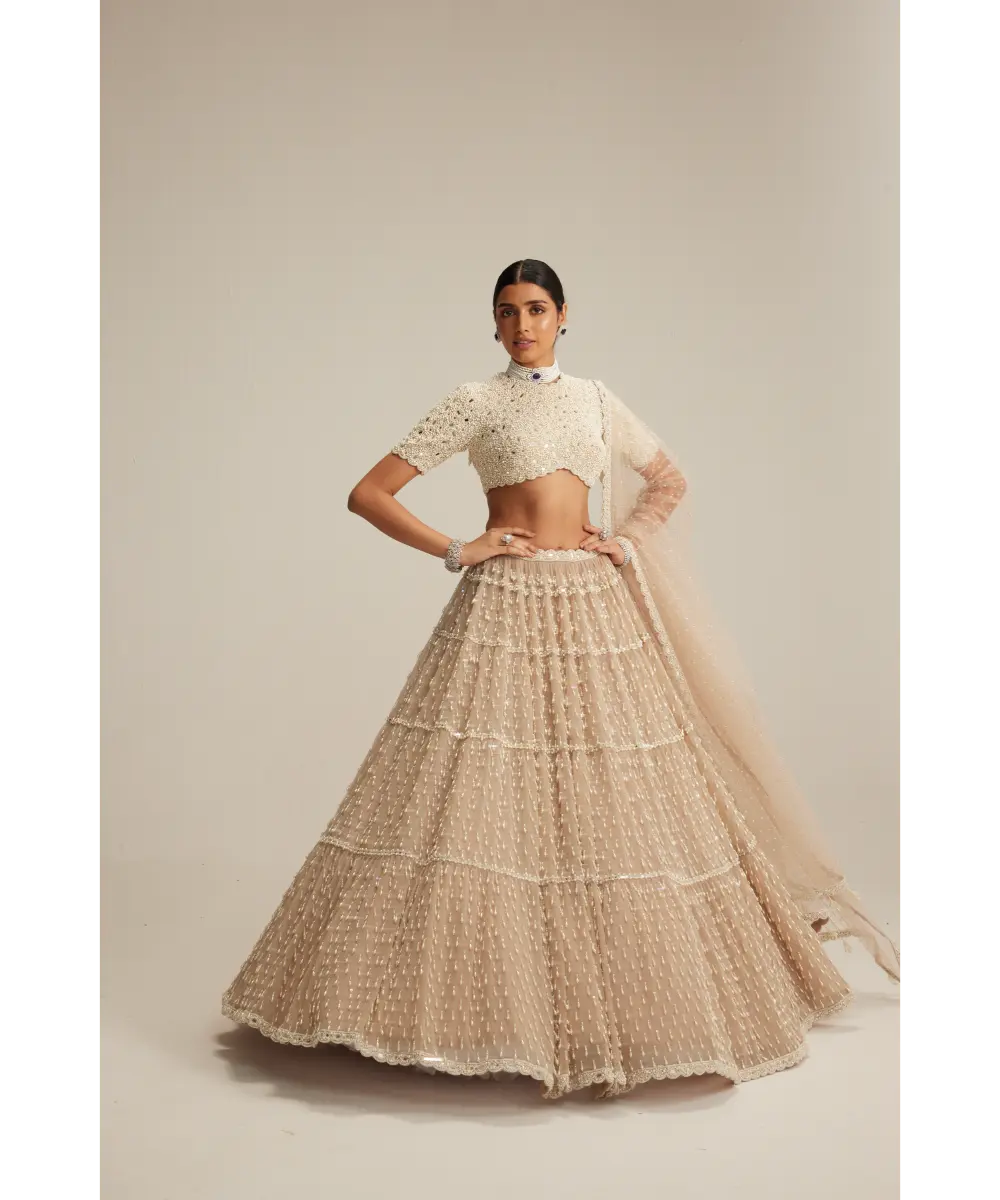 VVANI VATS- Light Beige Pearl Drop Multi Tier Lehenga With High Neck Blouse Set.